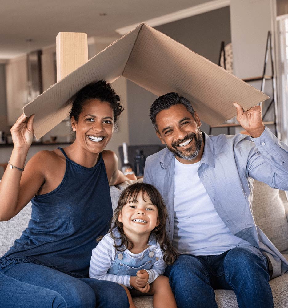 Happy family holding cardboard roof over heads
