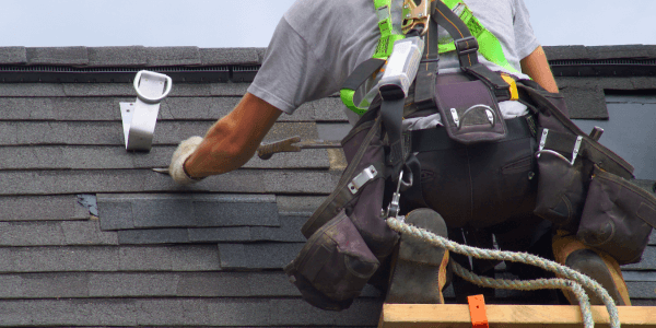 roofer installing impact-resistant roofing with security rope