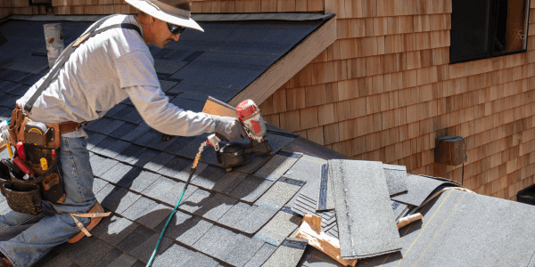 man installing asphalt roof during roof replacement