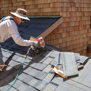 Man installing asphalt roof as common roof repairs