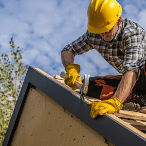 roofing contractor with hammer on rooftop